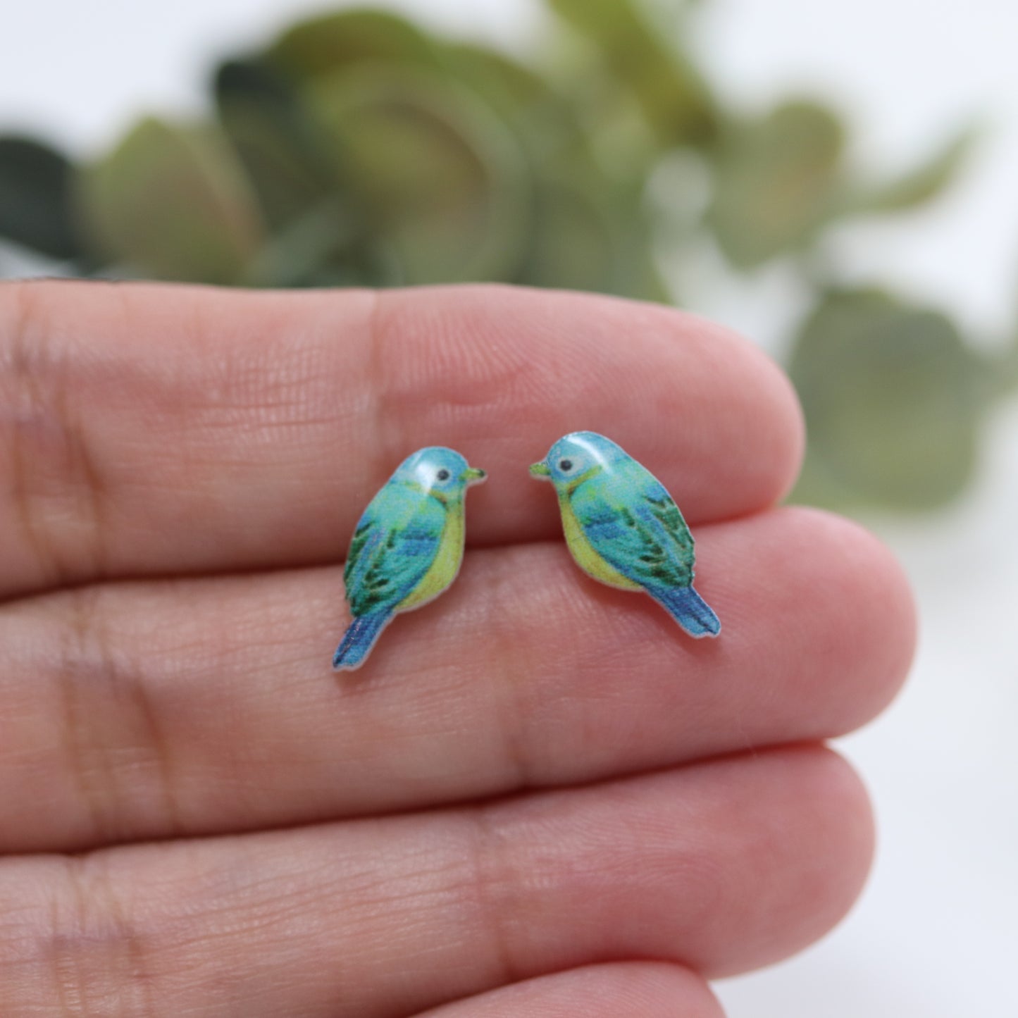 aqua bird earrings in a hand
