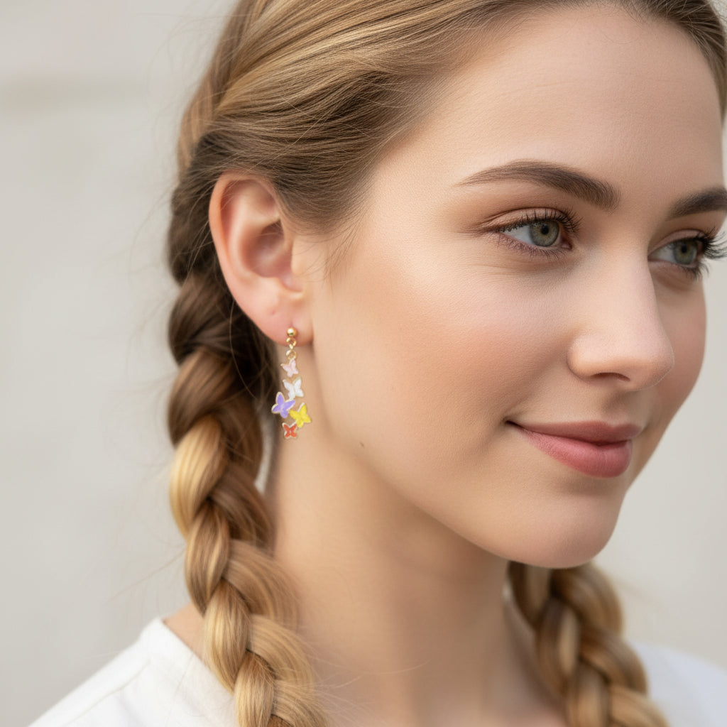 Close-up of an ear wearing colorful butterfly earrings with a blurred background.