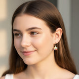 Close-up of an ear with a colorful flower-shaped earring.