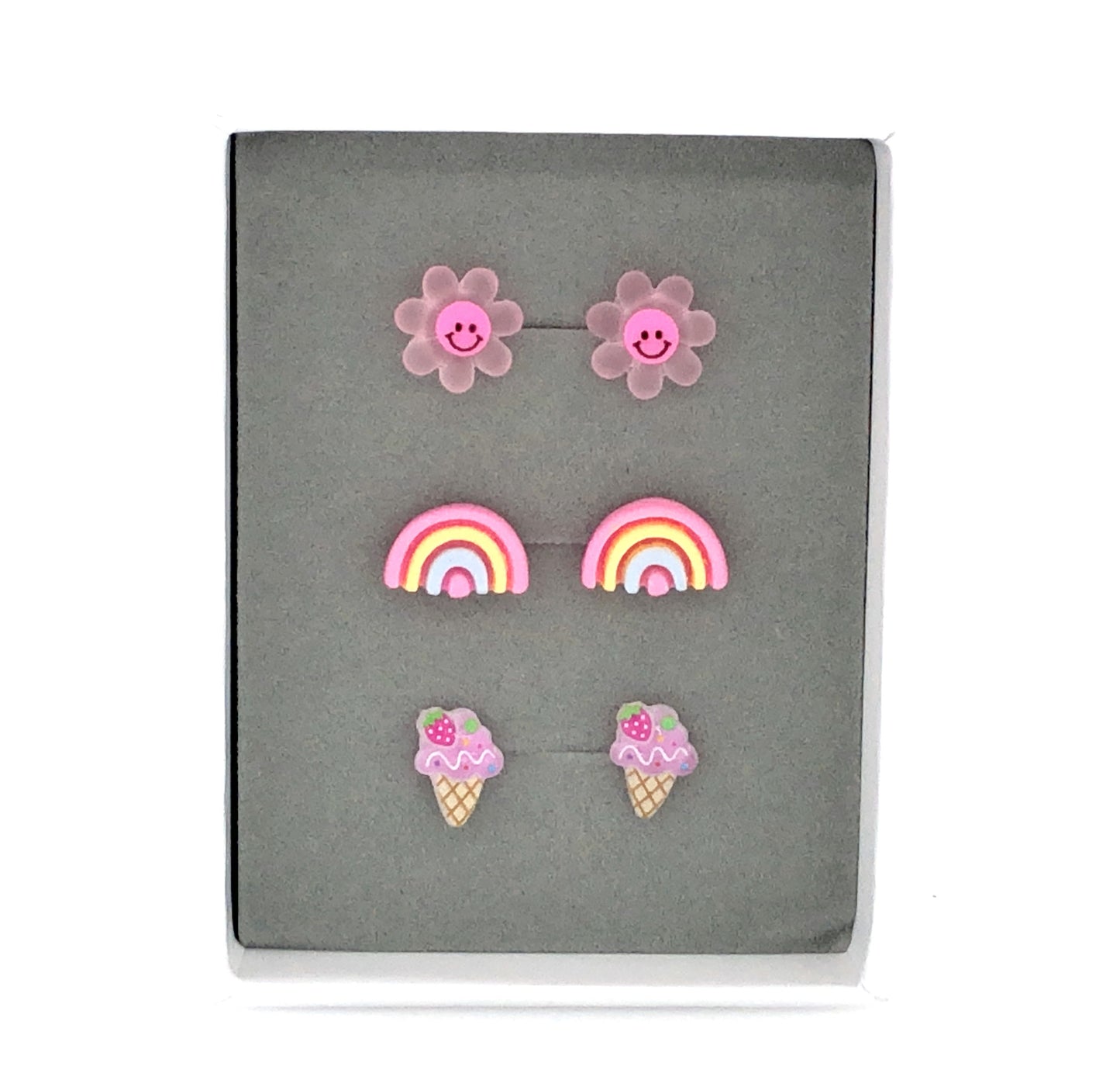 Three pairs of earrings featuring a dark pink smiley face daisy, a pink rainbow, and a purple ice cream cone design, presented in a box 