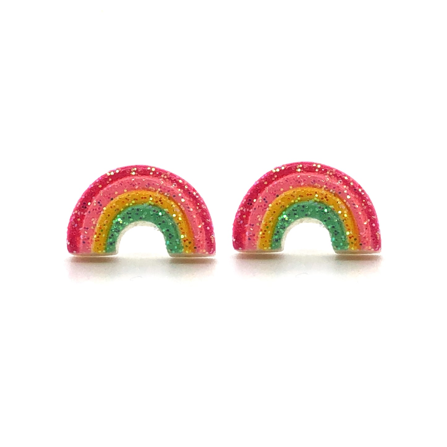 A pair of multicolored rainbow-shaped stud earrings with glitter on a white background.