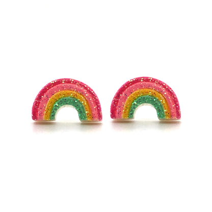 A pair of multicolored rainbow-shaped stud earrings with glitter on a white background.