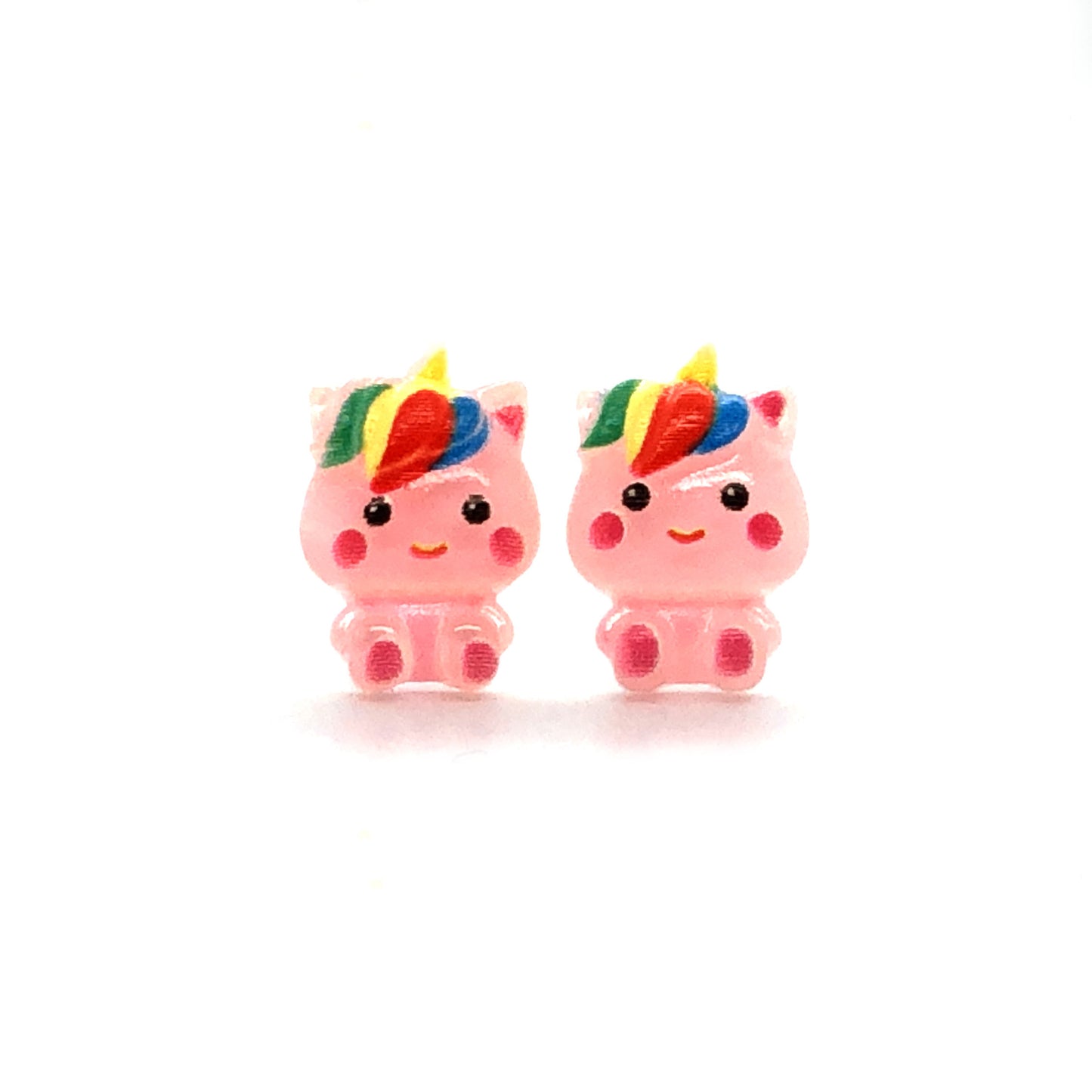 A pair of pink unicorn stud earrings with rainbow-colored manes, crafted from resin, displayed against a white background.