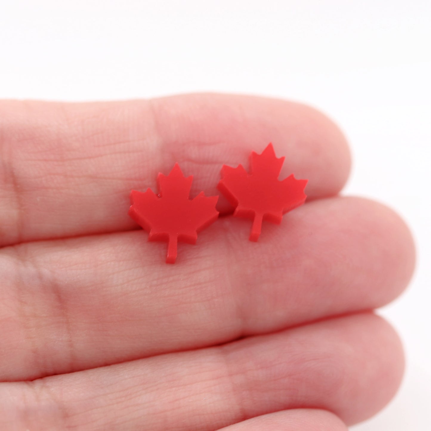 red maple leaf earrings in a hand