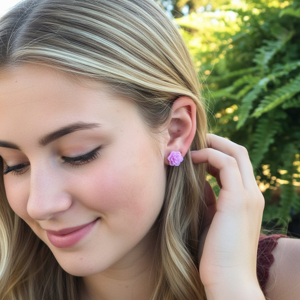Close-up of a person wearing a purple flower-shaped earring with a blurred natural background.