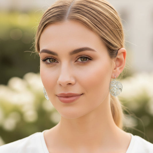 Woman wearing earrings with a blurred outdoor background