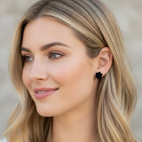 Red floral earring worn by a person with blonde hair.