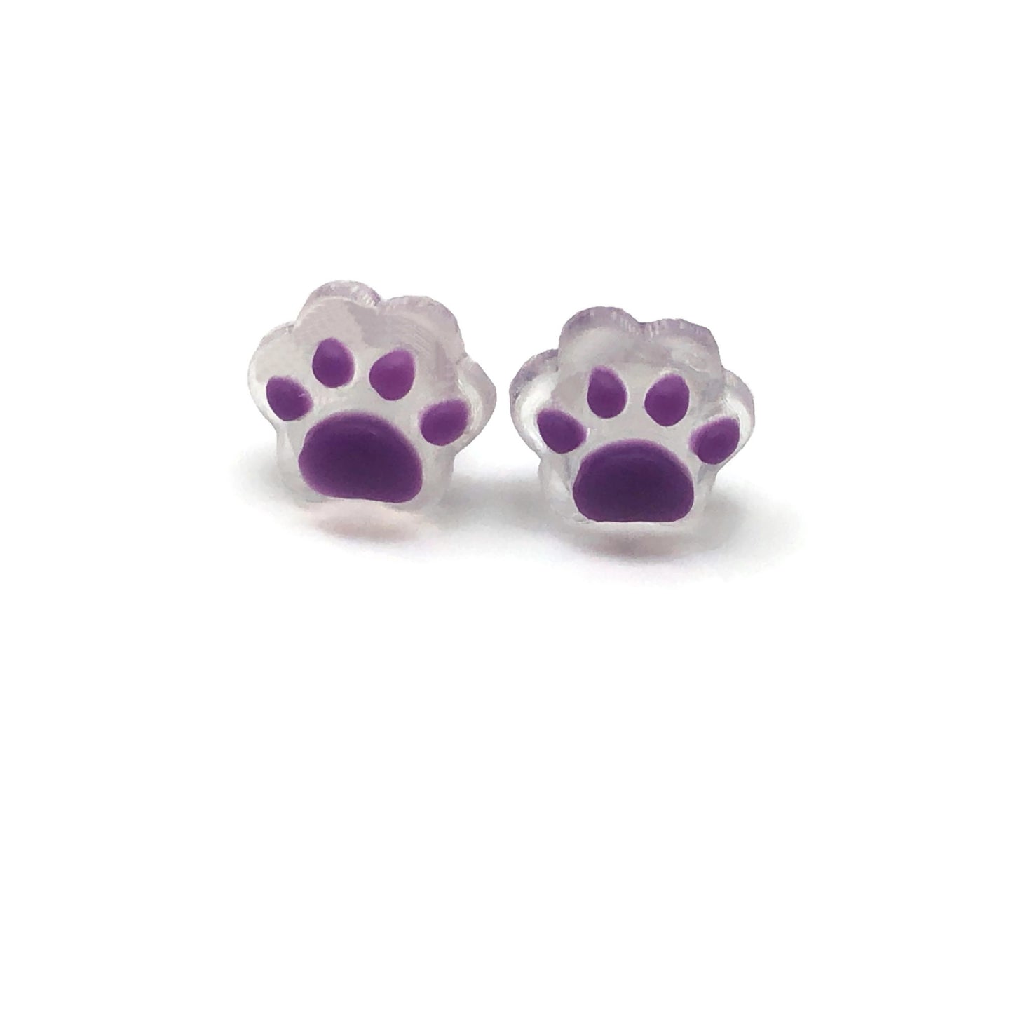 A pair of dainty paw print-shaped stud earrings in a beige color with brown details on a white background.