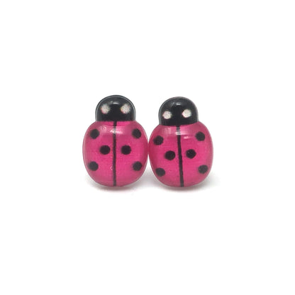 A pair of red ladybug stud earrings with black spots, designed for pierced ears with various post styles.