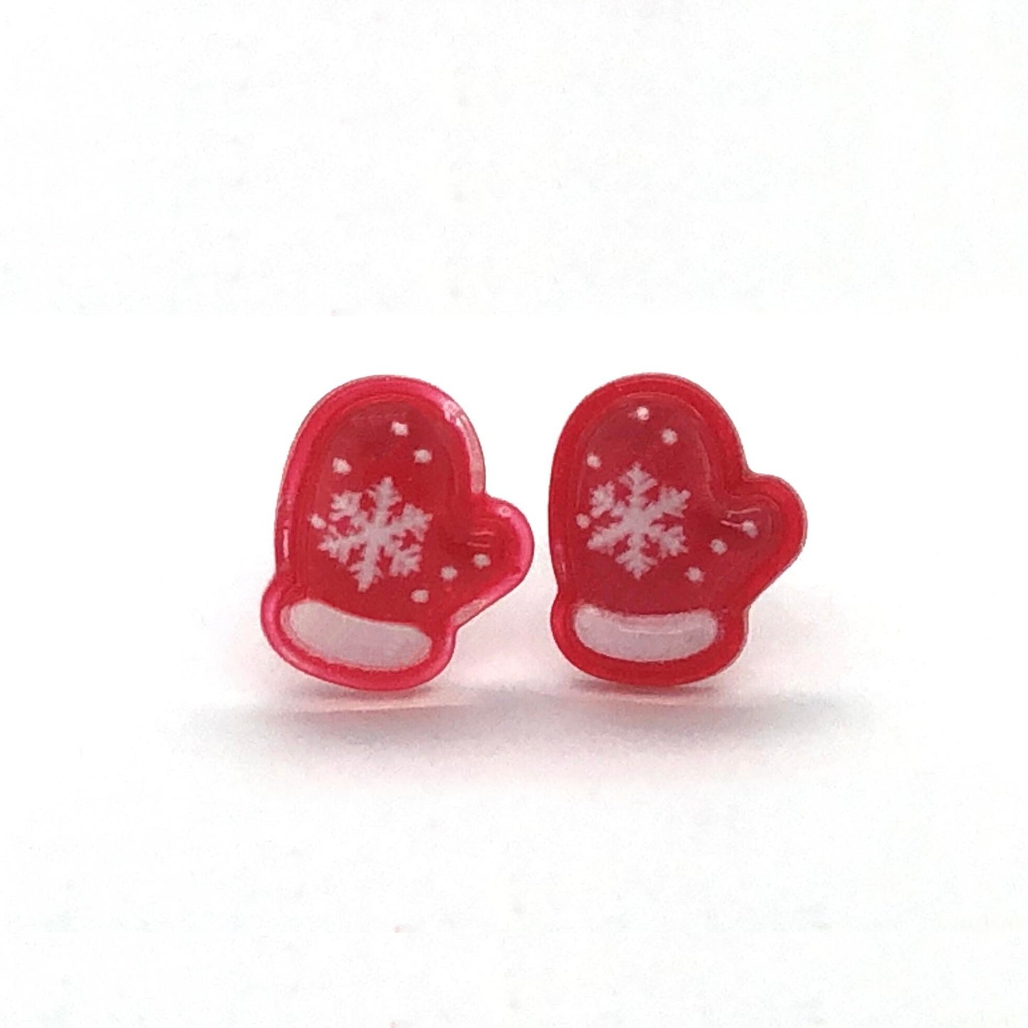 A pair of red mitten-shaped stud earrings with white snowflake patterns on them.