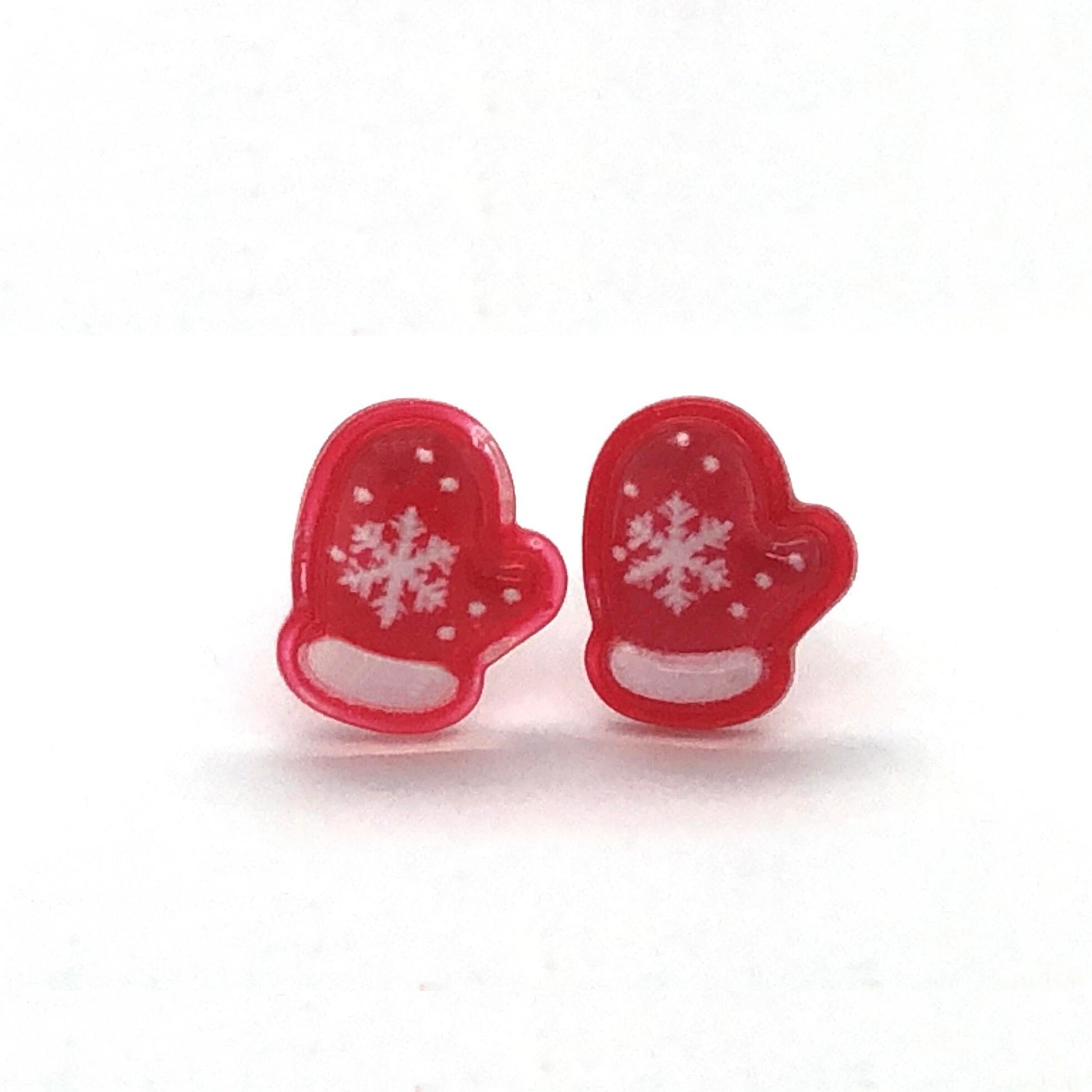 A pair of red mitten-shaped stud earrings with white snowflake patterns on them.