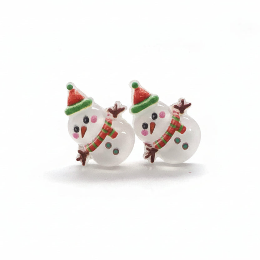 A pair of snowman-shaped stud earrings with colorful accents on the hat and scarf, made of resin, displayed against a white background.
