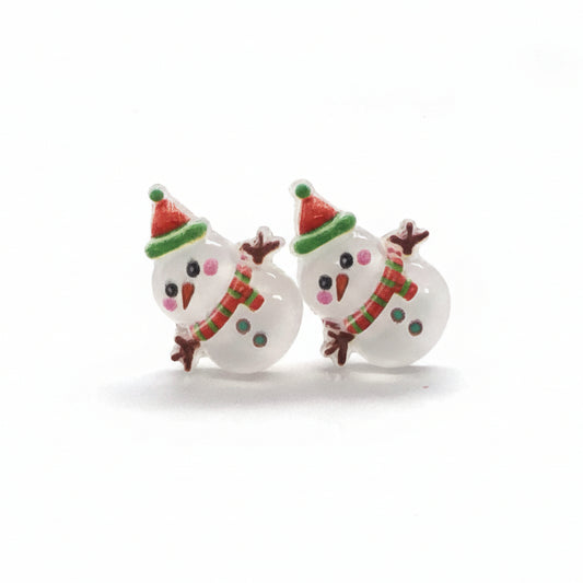 A pair of snowman-shaped stud earrings with colorful accents on the hat and scarf, made of resin, displayed against a white background.