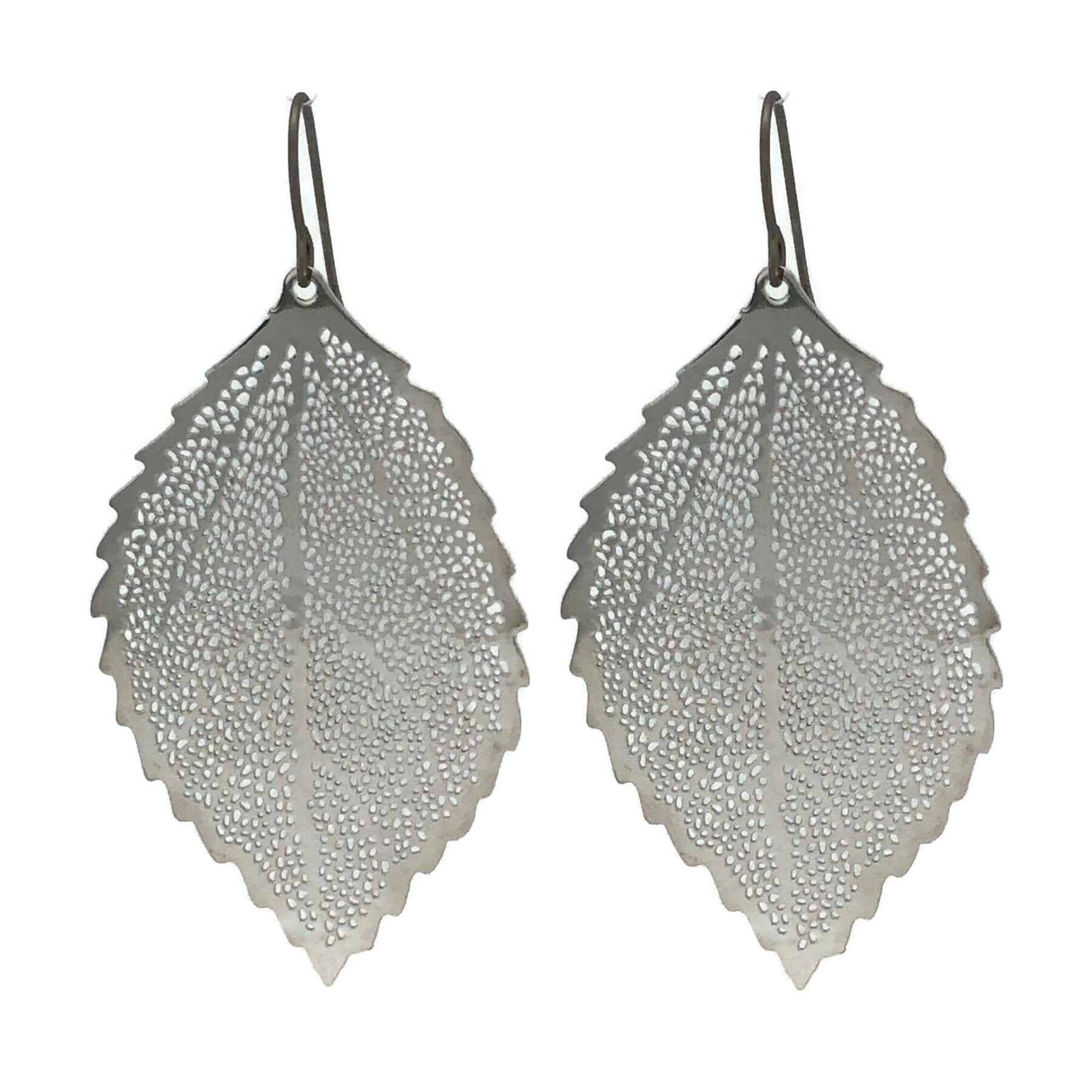A pair of silver dangle earrings designed to resemble a leaf, with a textured surface and rounded edges.