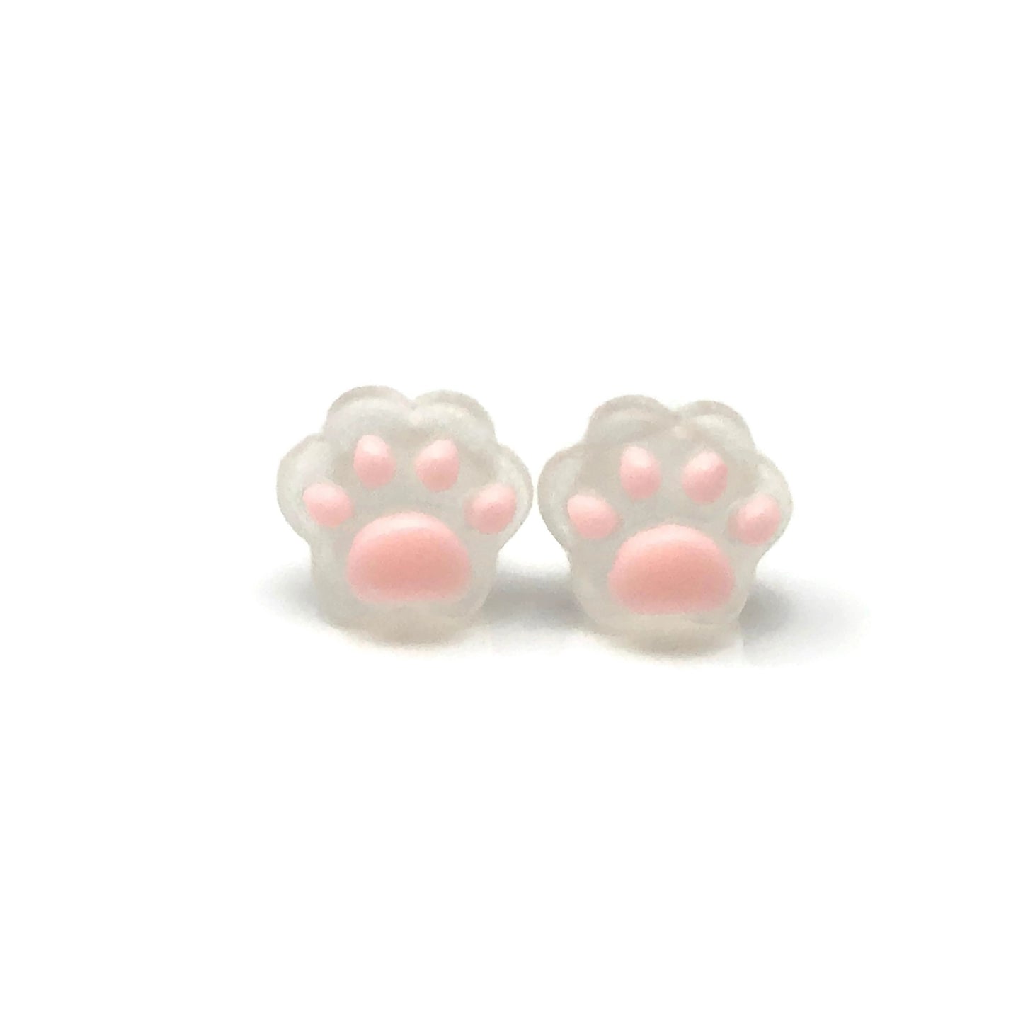 A pair of dainty paw print-shaped stud earrings in a beige color with brown details on a white background.