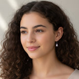 Close-up of an ear wearing a small earring with a unicorn design.