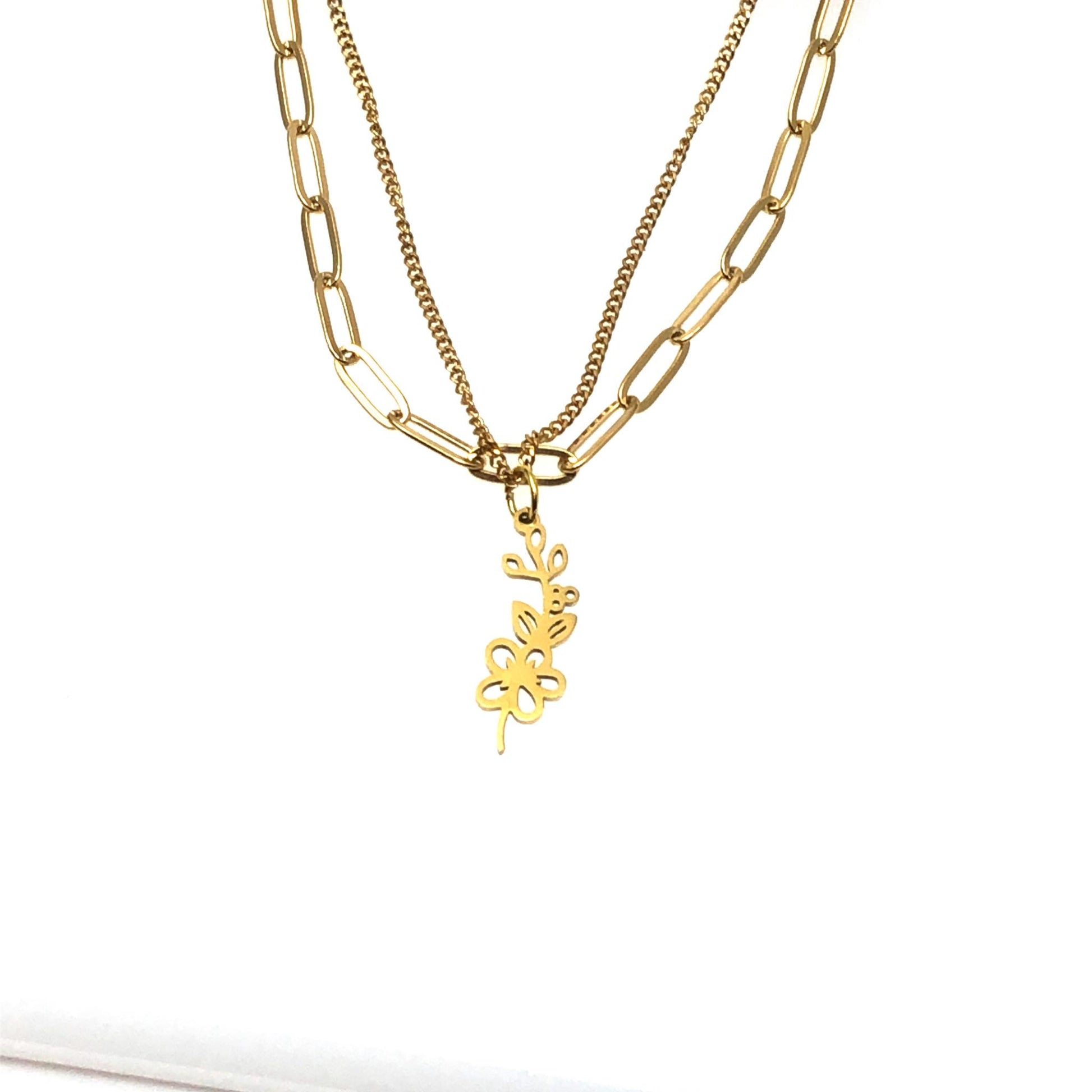 gold color paperclip necklace layered with a curb chain and hawthorne may birthmonth flower necklace