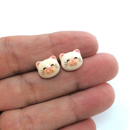 beige cat face earring in a hand