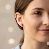 Close-up of an ear wearing a pink mermaid tail earring with a blurred background