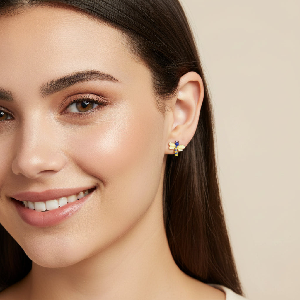 Close-up of an ear with a blue and yellow dragonfly earring.