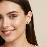 Close-up of an ear with a blue and yellow dragonfly earring.