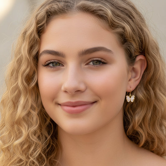 Close-up of an ear wearing a butterfly-shaped earring with blurred background