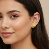 Close-up of a person wearing a orange pumpkin-shaped earring with a blurred background