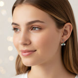 Close-up of an ear with rainbow and cloud earrings.