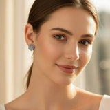 Gray succulent-shaped earring on a white earbud against a light gray background