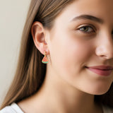 Close-up of an ear with watermelon slice earrings and additional jewelry.