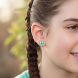Close-up of an ear wearing a butterfly-shaped earring with blurred background