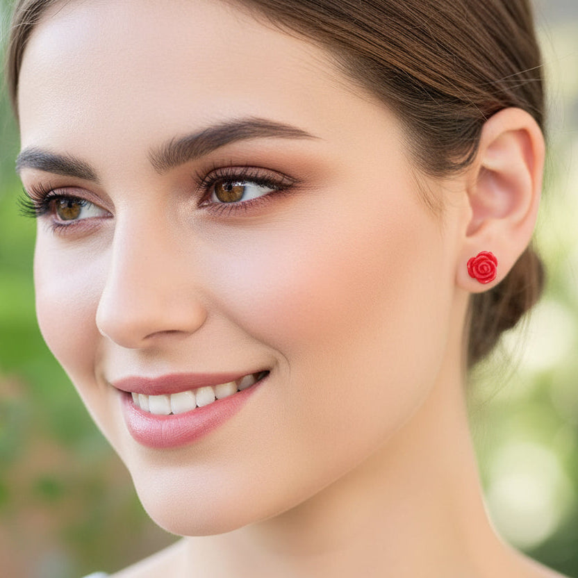 Close-up of an ear wearing a red rose earring with braided hair.