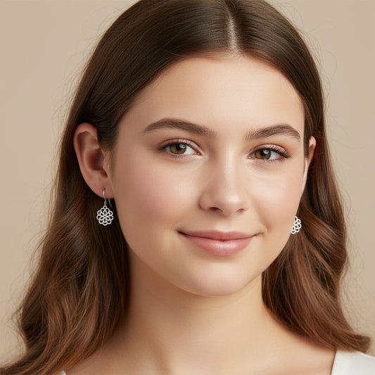 Close-up of a person wearing a floral silver earring with blurred background