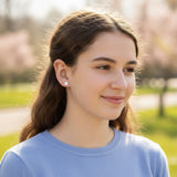Close-up of an ear wearing two small earrings with a blurred background