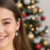 Gingerbread man-shaped earring worn by a person with brown hair.