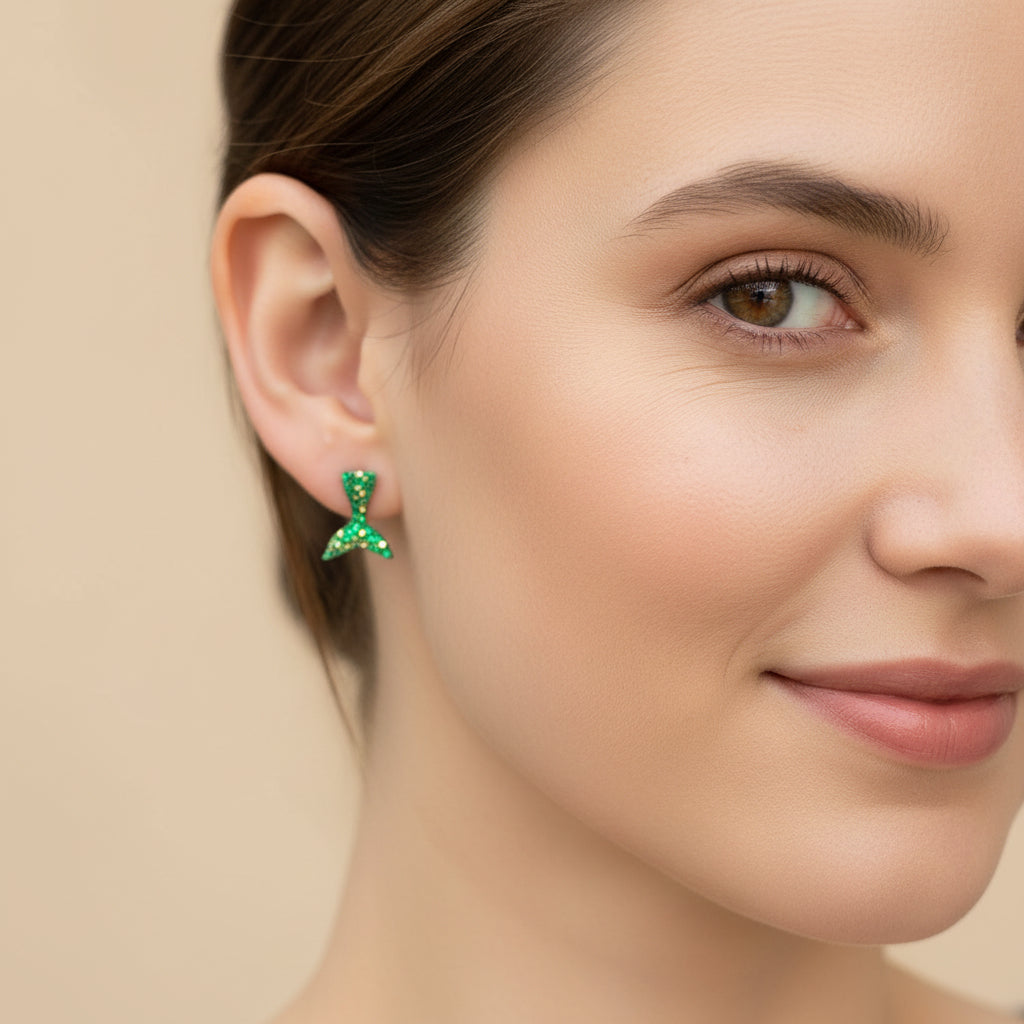 Close-up of an ear wearing a green mermaid tail earring.