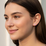 Close-up of an ear wearing a pink bunny ear earring with a bow
