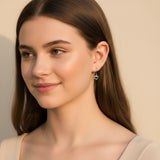 Close-up of an ear wearing two earrings with a soft background
