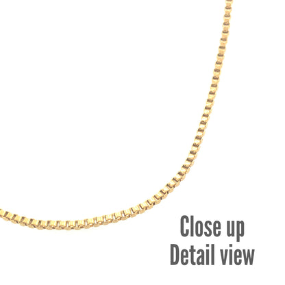Close-up detail view of a gold-colored box chain necklace with a smooth, polished finish.