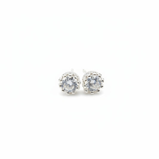 Silver earrings with clear gemstones on a light background