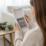 Set of Christmas-themed earrings in a box being opened by a teen model