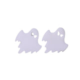 Ghost-shaped earrings on a reflective surface with a blurred green background