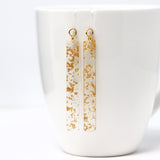 Gold earrings with a white background