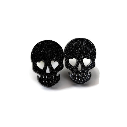 Black glitter skull-shaped earrings on a white background