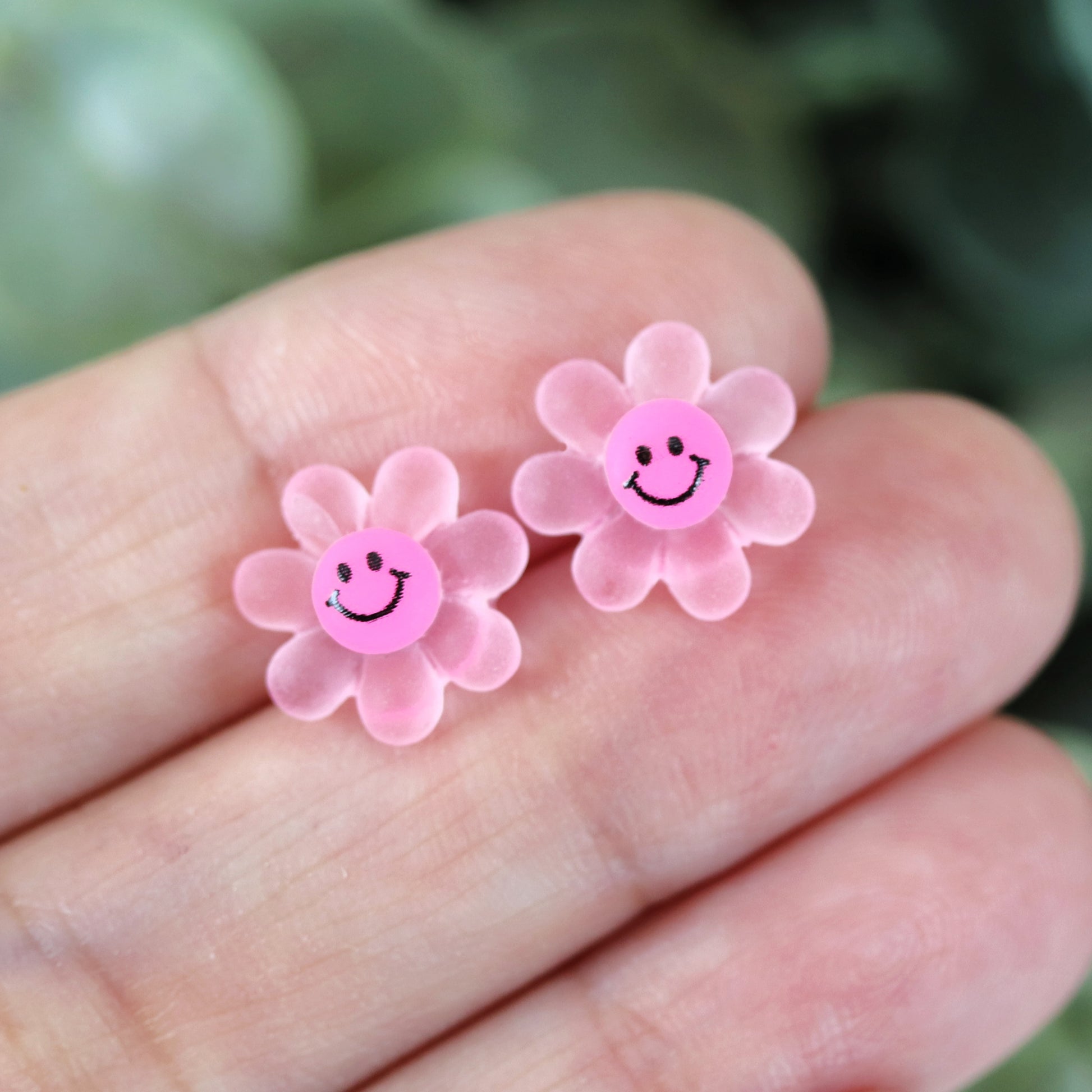 pink smiley face flower in hand
