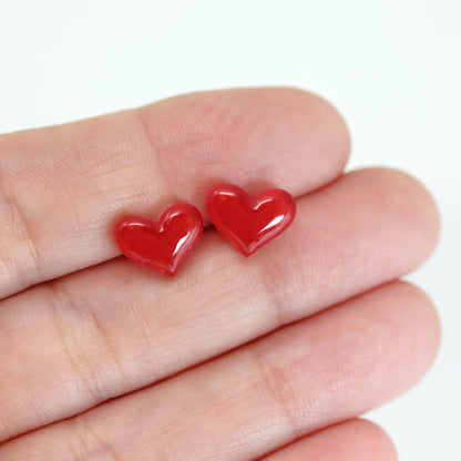 red heart earrings in hand