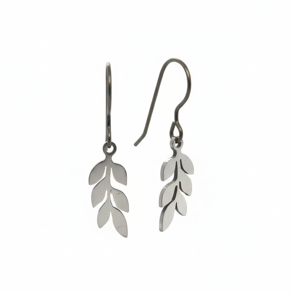 A pair of dangle earrings with leaf-shaped metal charms attached to hooks, displayed against a white background.