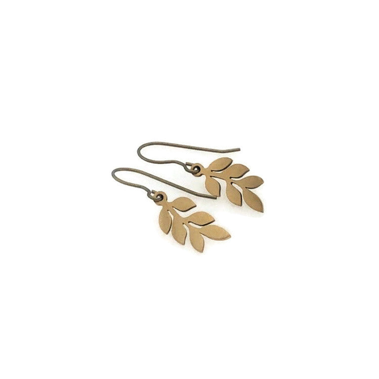 Gold leaf-shaped earrings on a white background