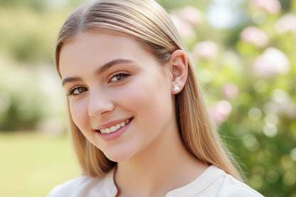 Close-up of an ear wearing a bunny-shaped earring with a blurred natural background
