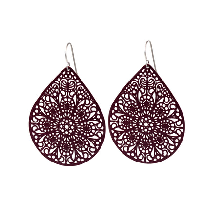 A pair of teardrop-shaped earrings with a lace filigree design in a dark color.